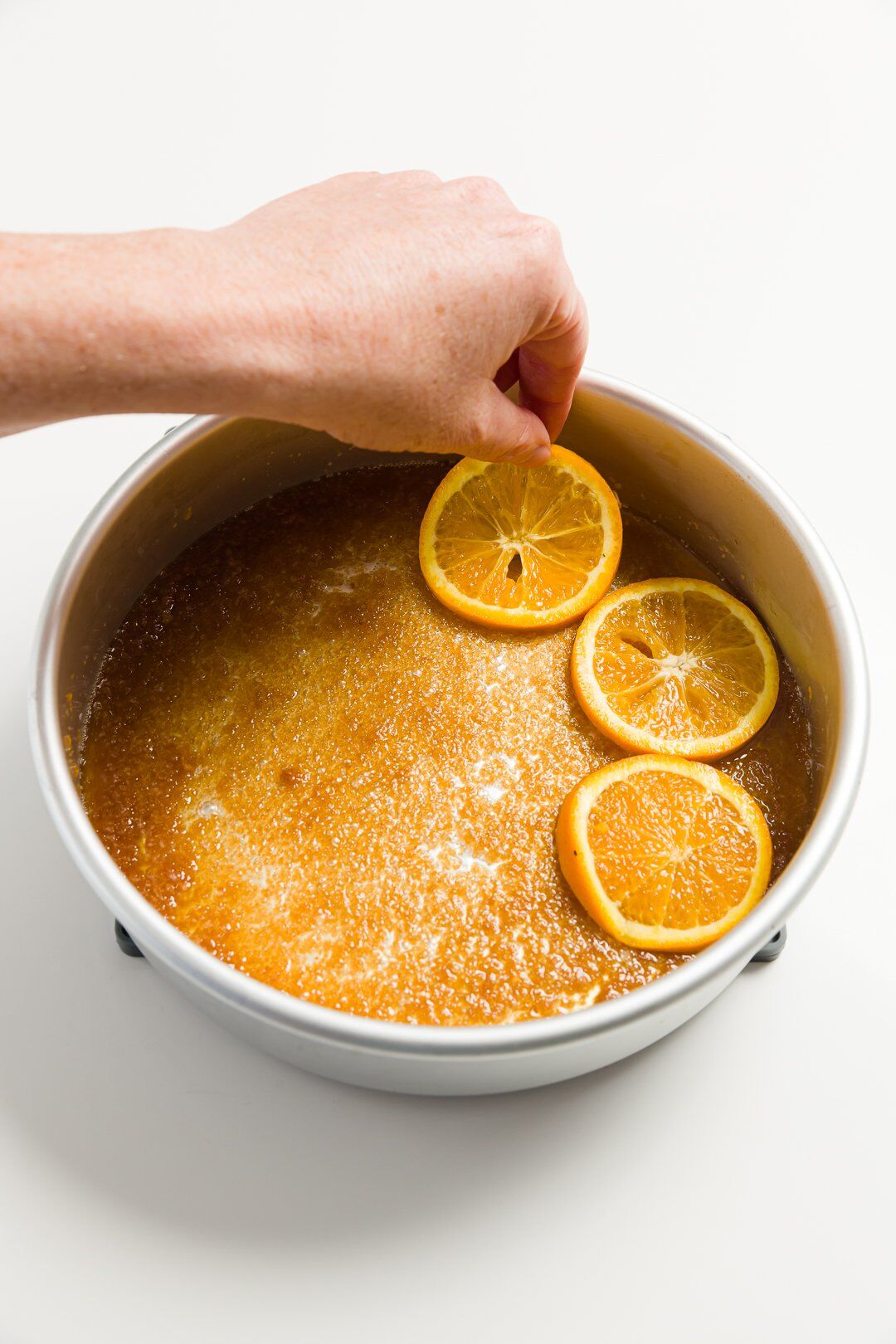 Placing sliced oranges in the pan