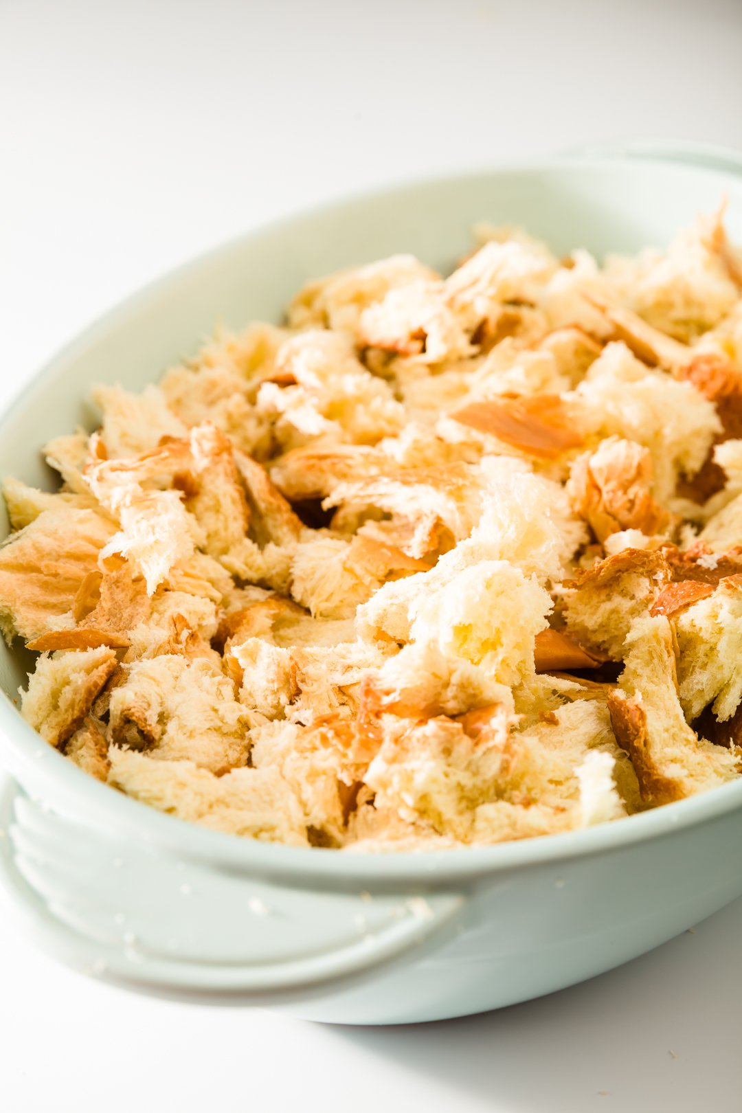 Brioche ripped into pieces in an oval casserole dish