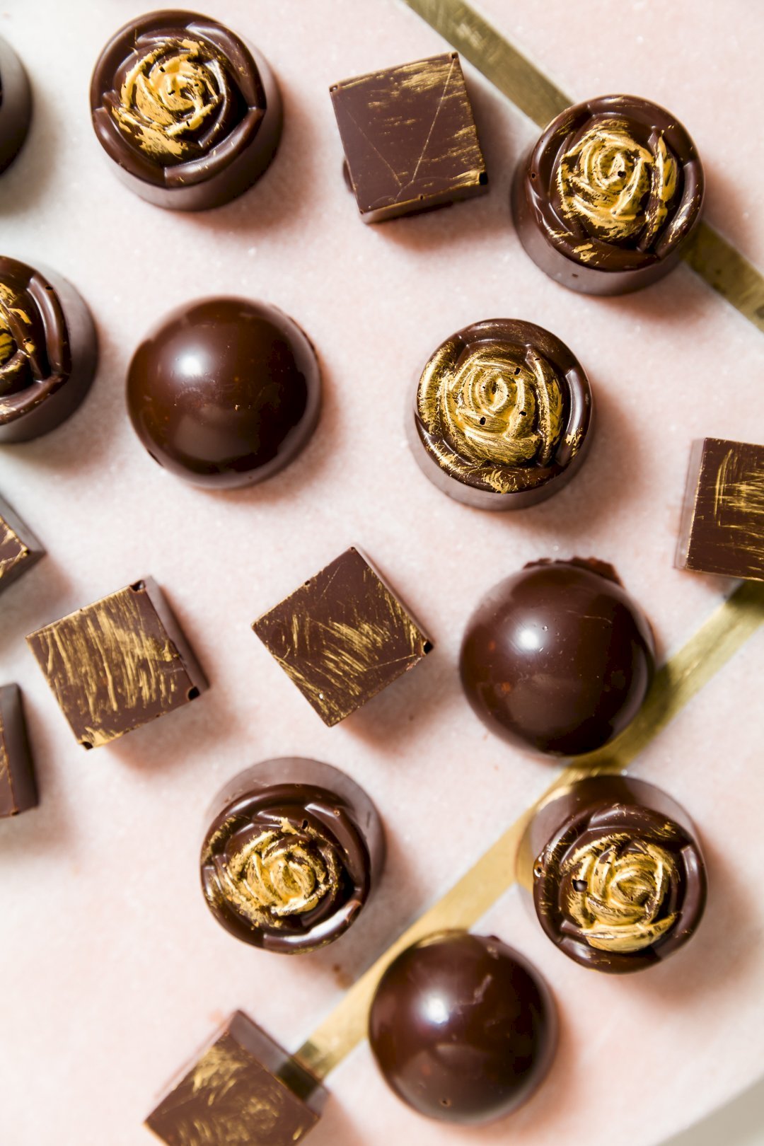 A number of chocolate bonbons on a marble slab