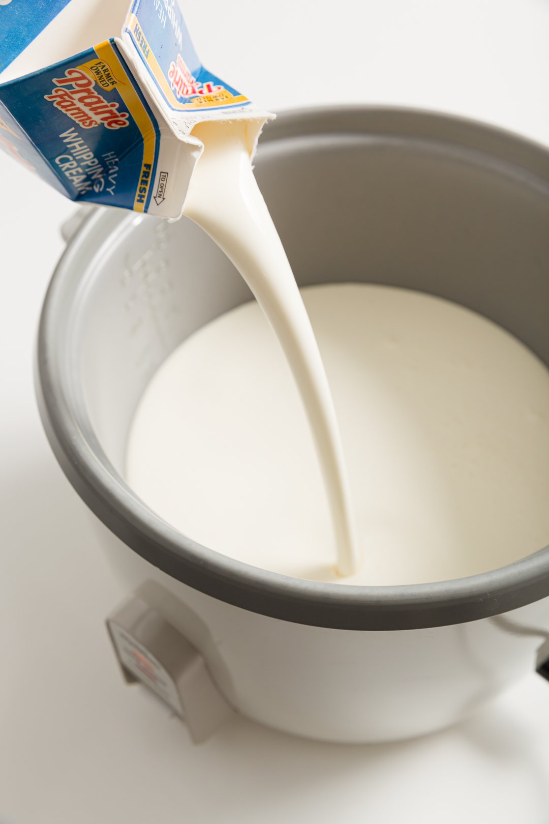 Heavy whipping cream being poured into a rice cooker