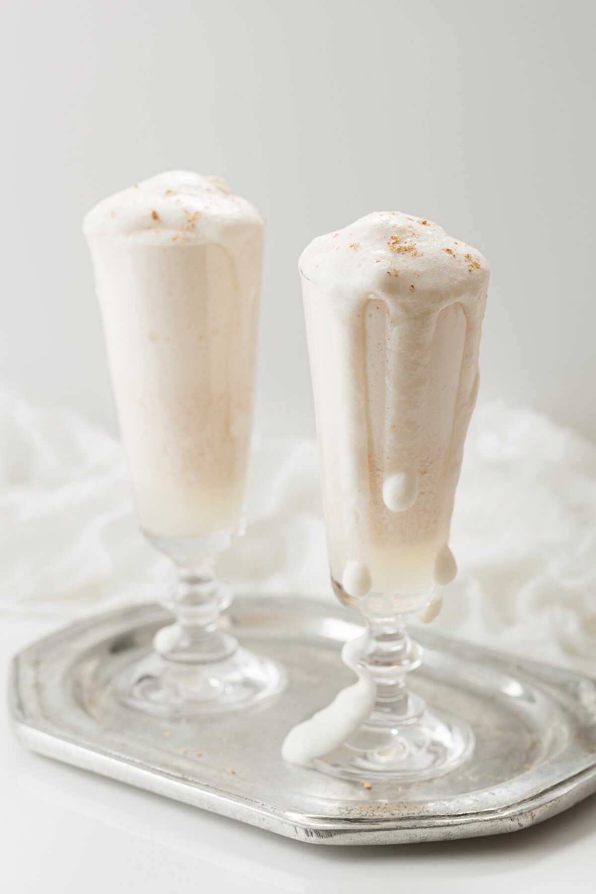 looking down slightly at two syllabub cocktails on a silver tray