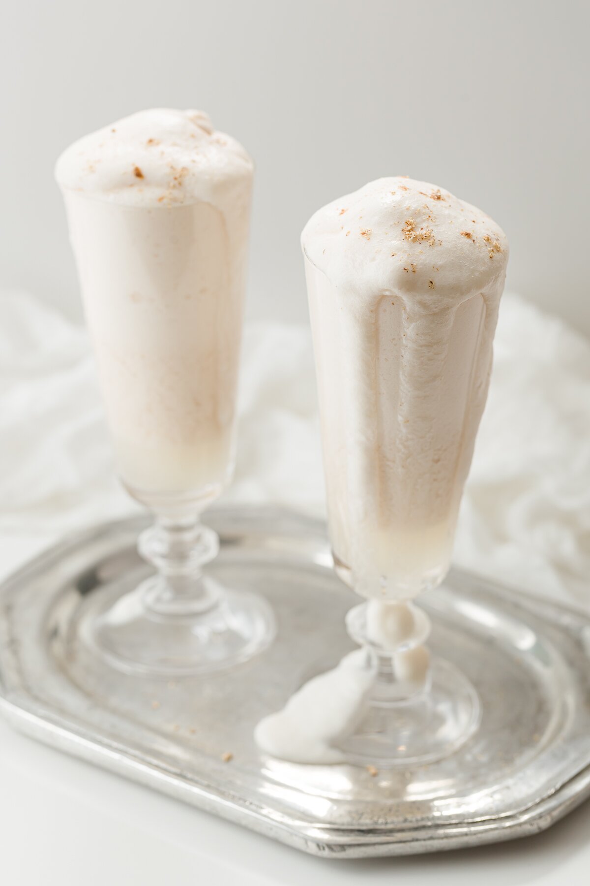 looking down at two syllabub cocktails on a silver tray