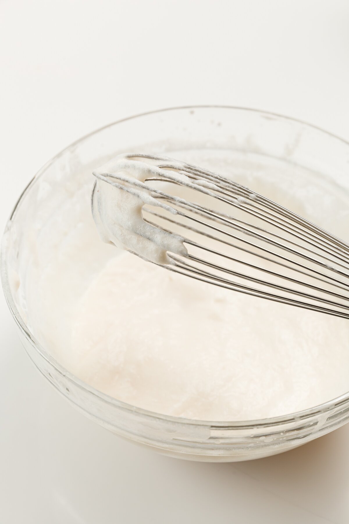 a whisk coated in froth from making a syllabub