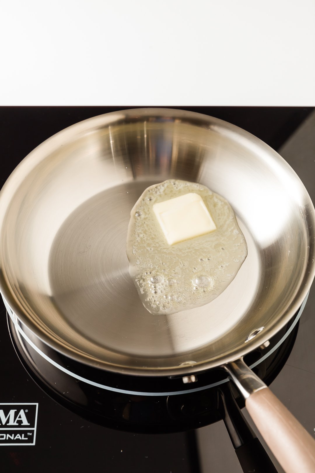 A pat of butter melting in a skillet