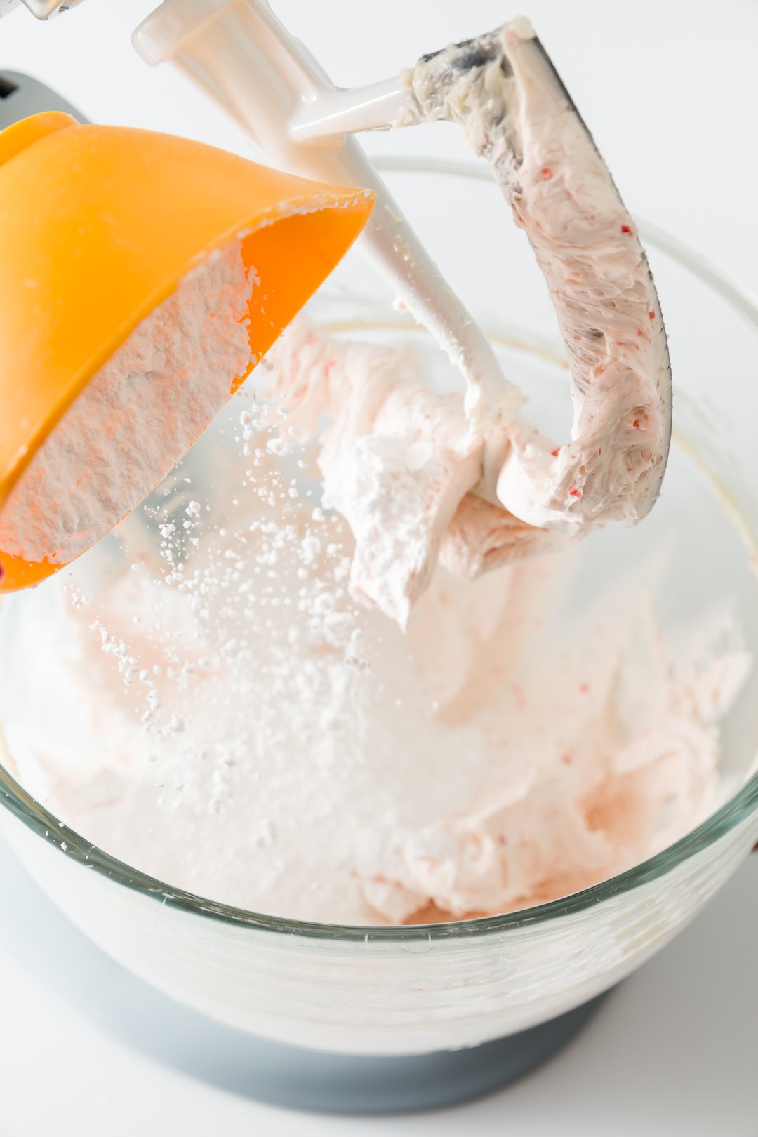 Adding powdered sugar to strawberry frosting