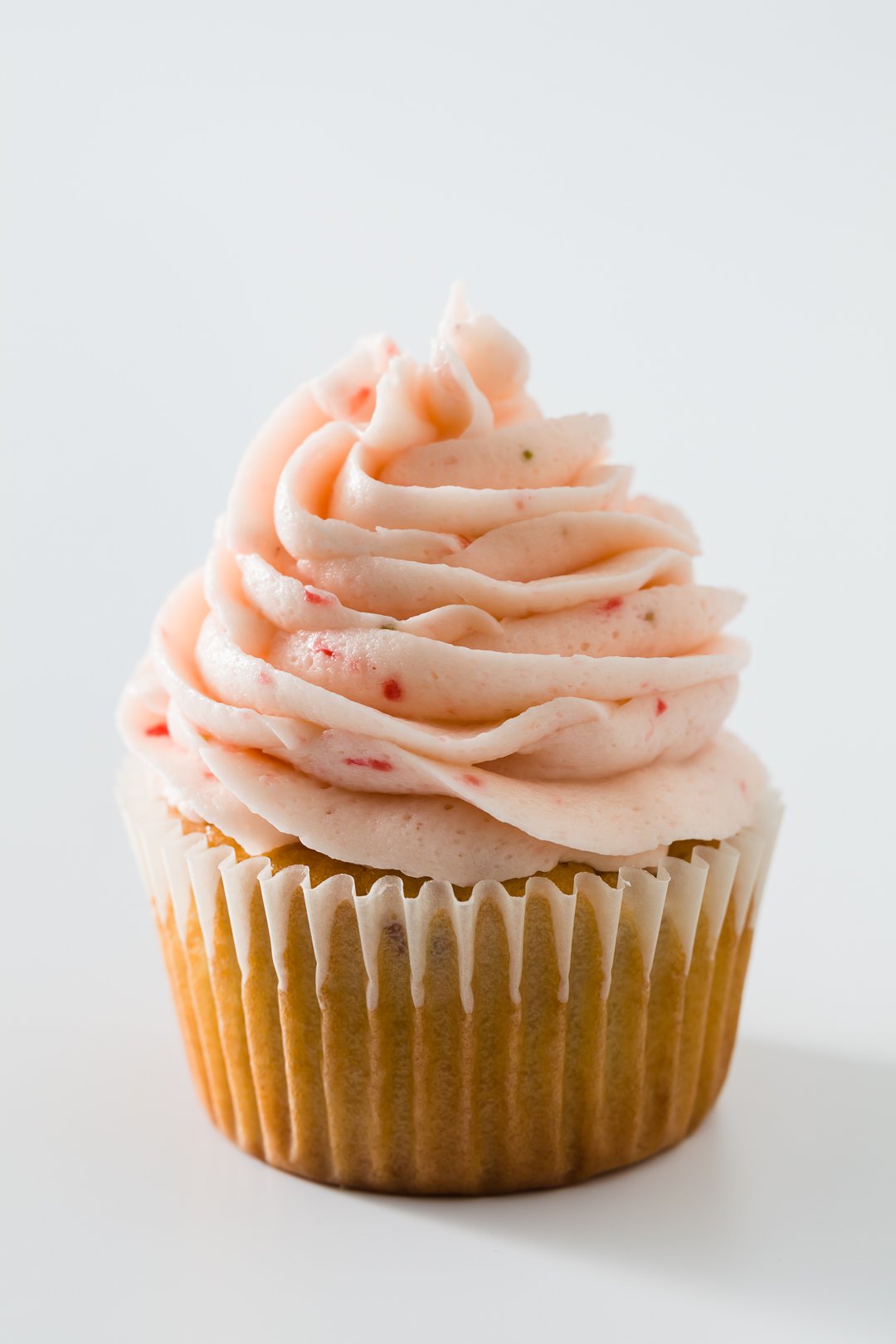 One strawberry cupcake with strawberry buttercream frosting