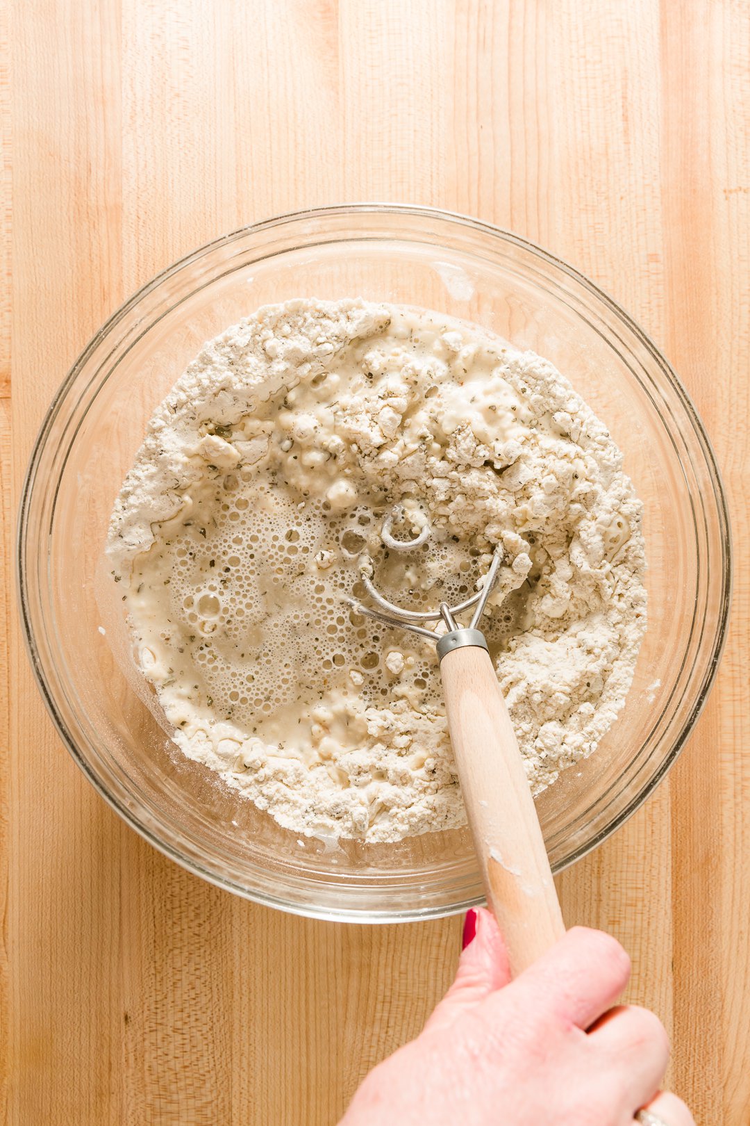 Mixing pizza dough with dough whisk