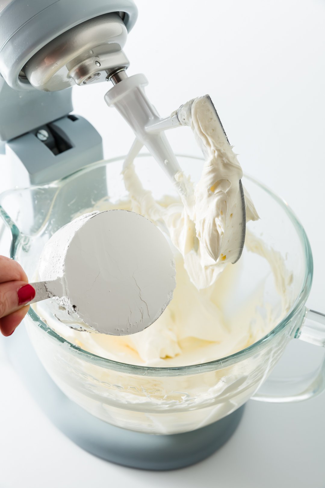 Adding powdered sugar to lemon cream cheese frosting