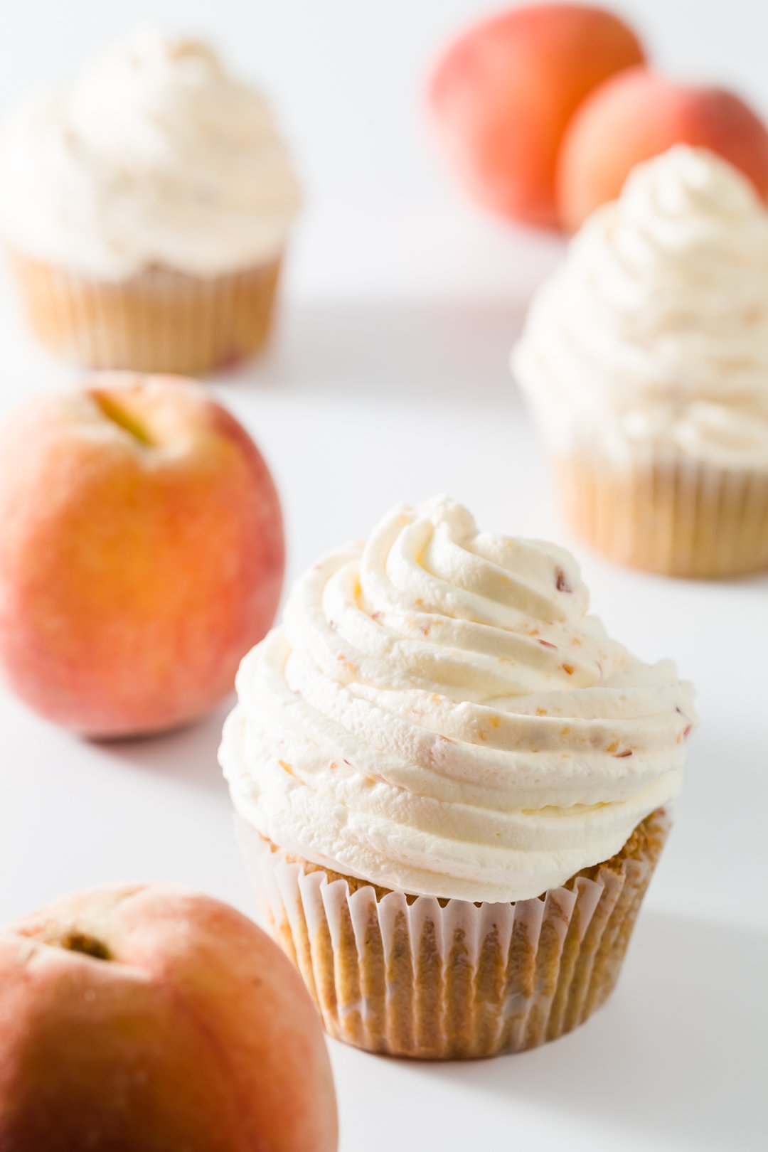 Cupcakes topped with peach whipped cream