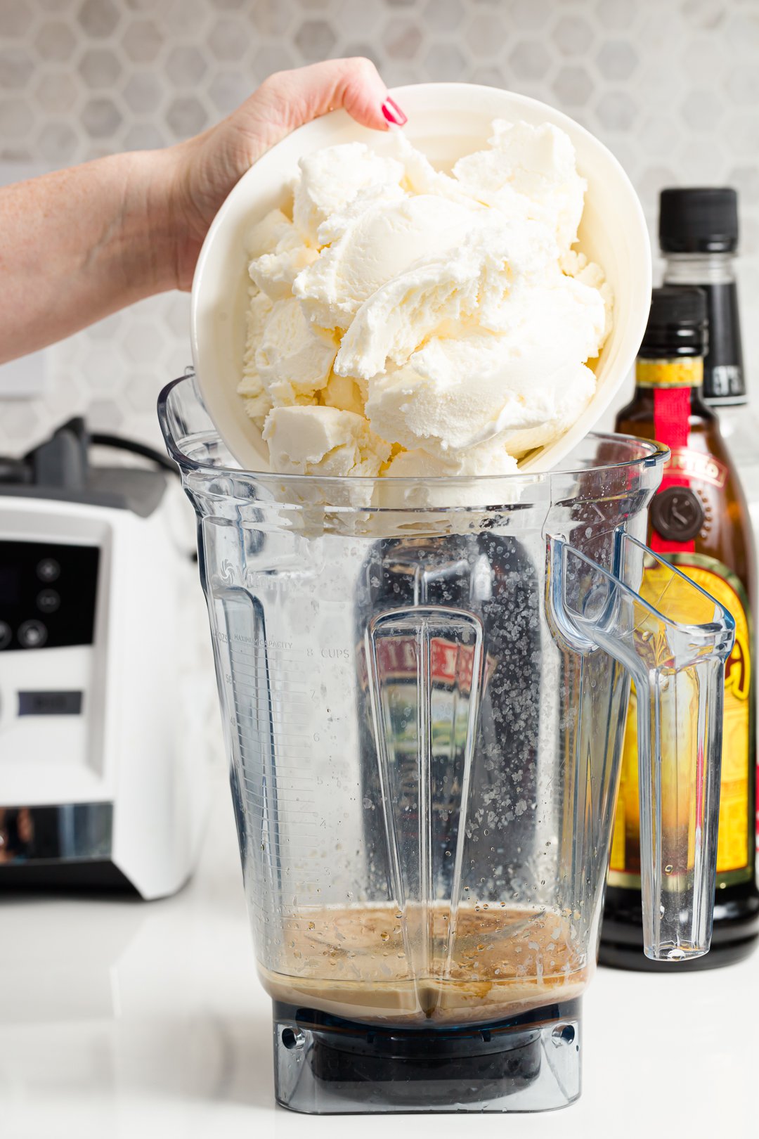 Stef adding ice cream to a blender to make a frozen mudslide drink