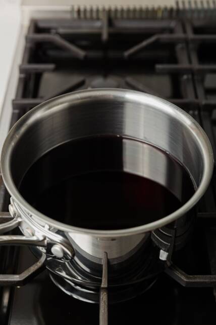 olla llena de jugo de granada descansando sobre una estufa