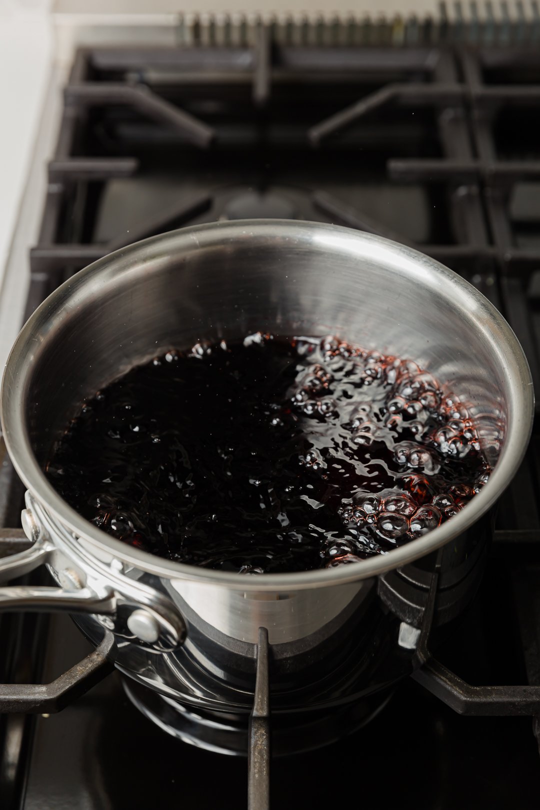 pomegranate juice rapidly boiling in a pot on a range