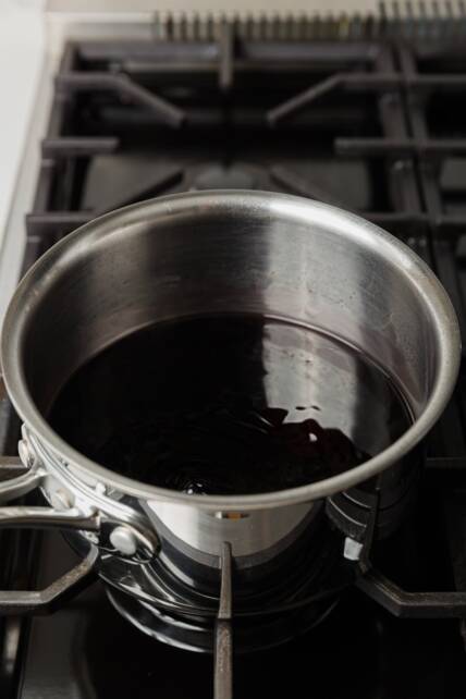 jugo de granada reducido a la mitad, hirviendo lentamente en una olla en un rango