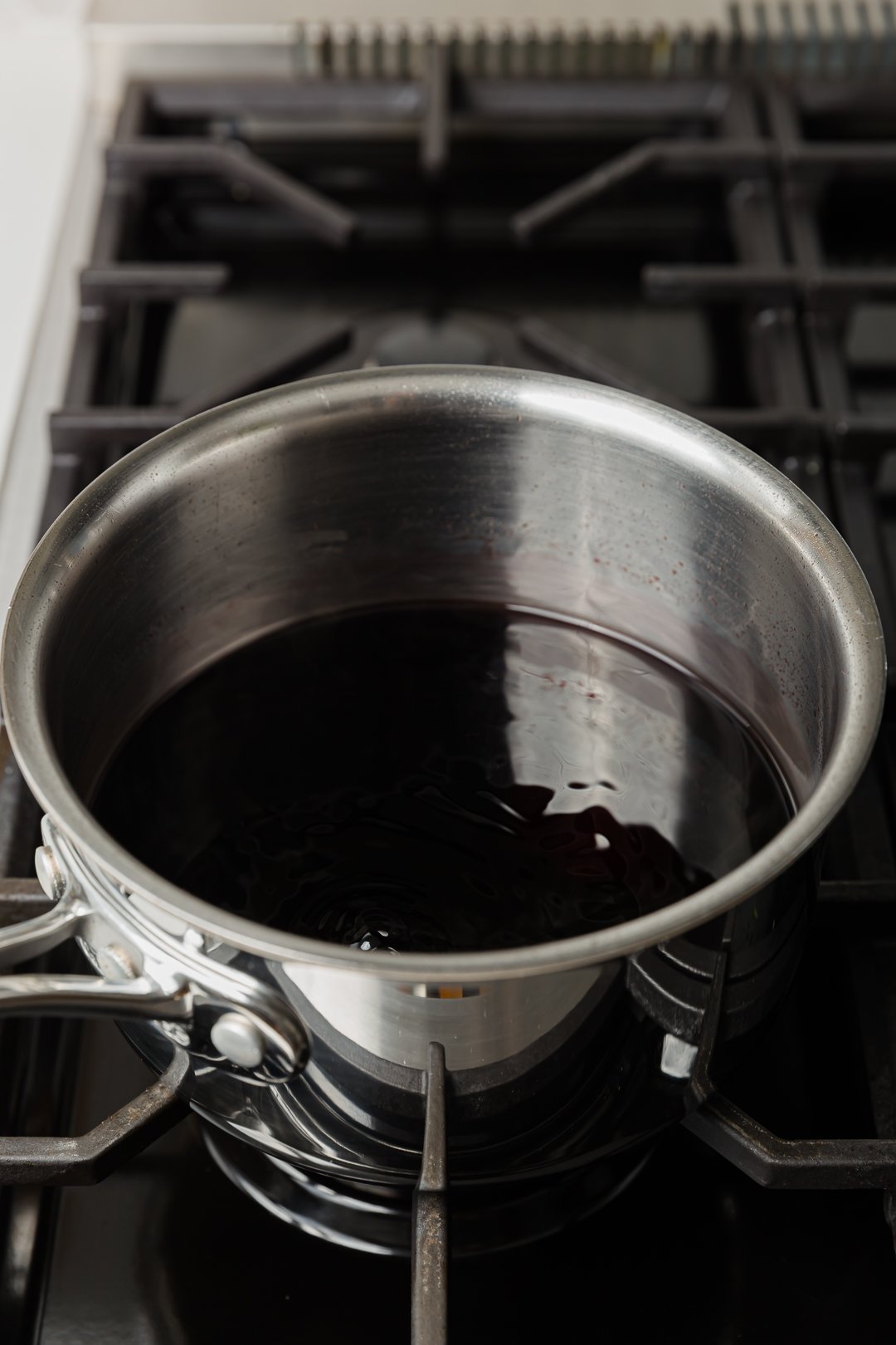 pomegranate juice reduced by half, slowly boiling in a pot on a range