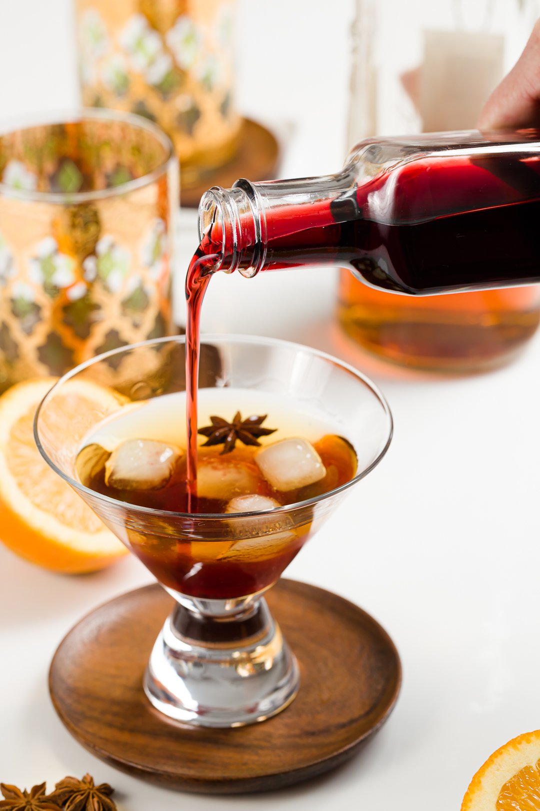 homemade grenadine being poured into a bourbon cocktail