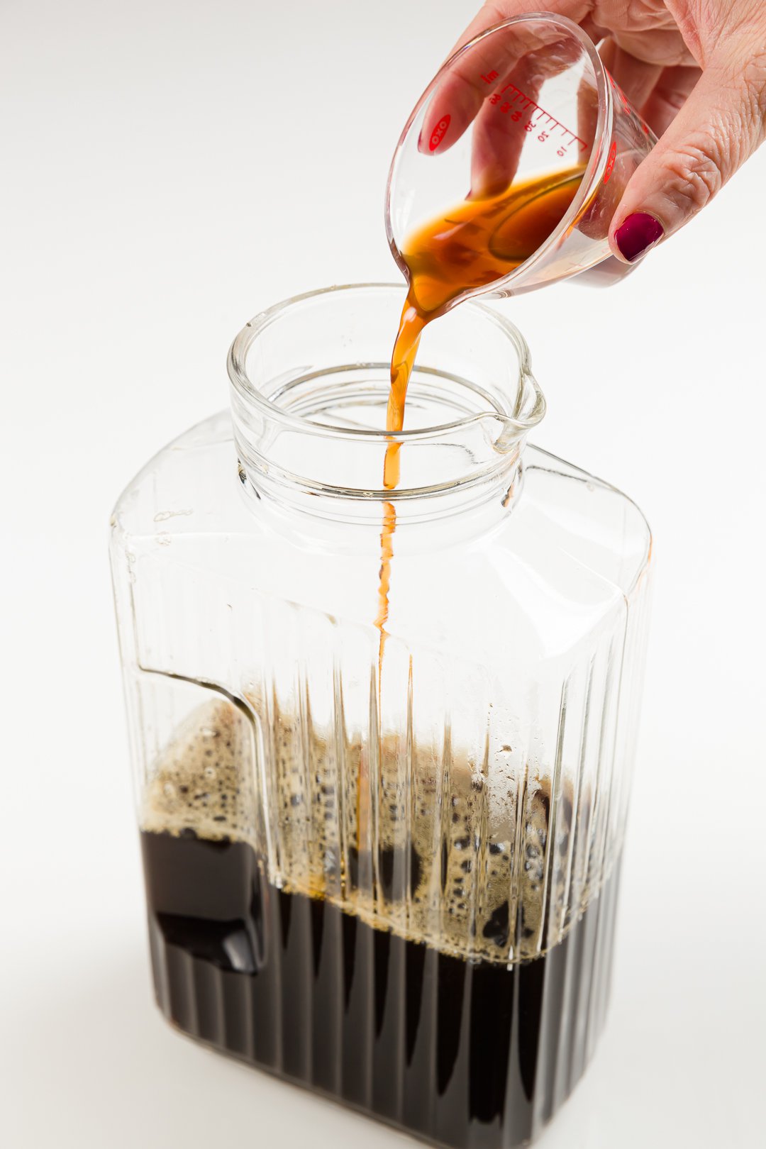 adding vanilla extract to sweetened coffee in a jug to make homemade Kahlua