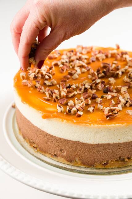 agregando nueces a la parte superior del pastel de queso de tortuga