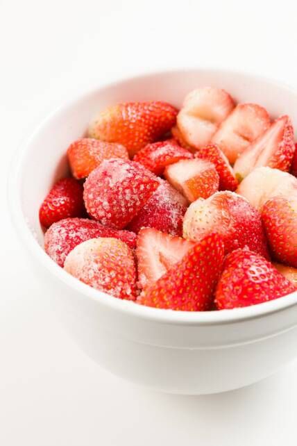 Un tazón grande de fresas cubiertas con azúcar