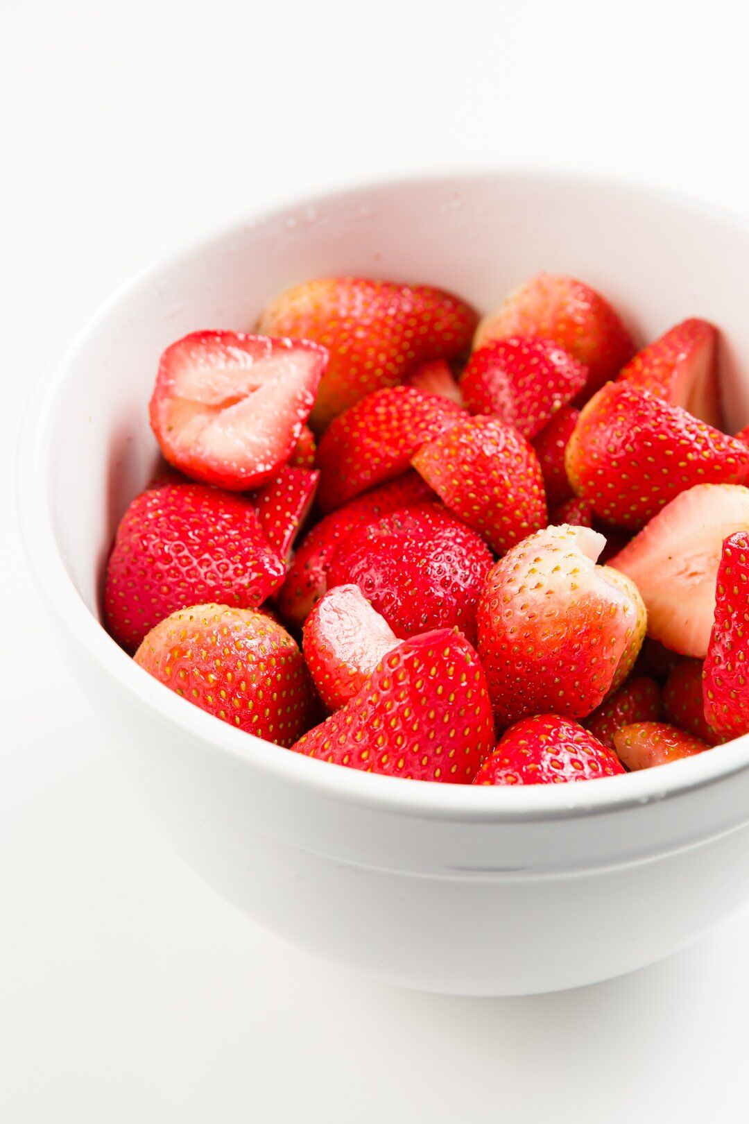 A large bowl of strawberries macerated overnight in sugar