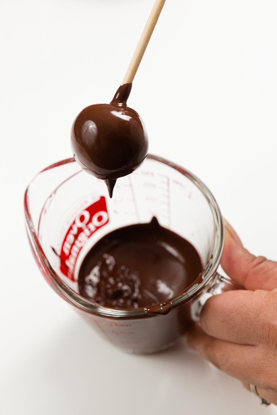 Dipping cake ball into chocolate