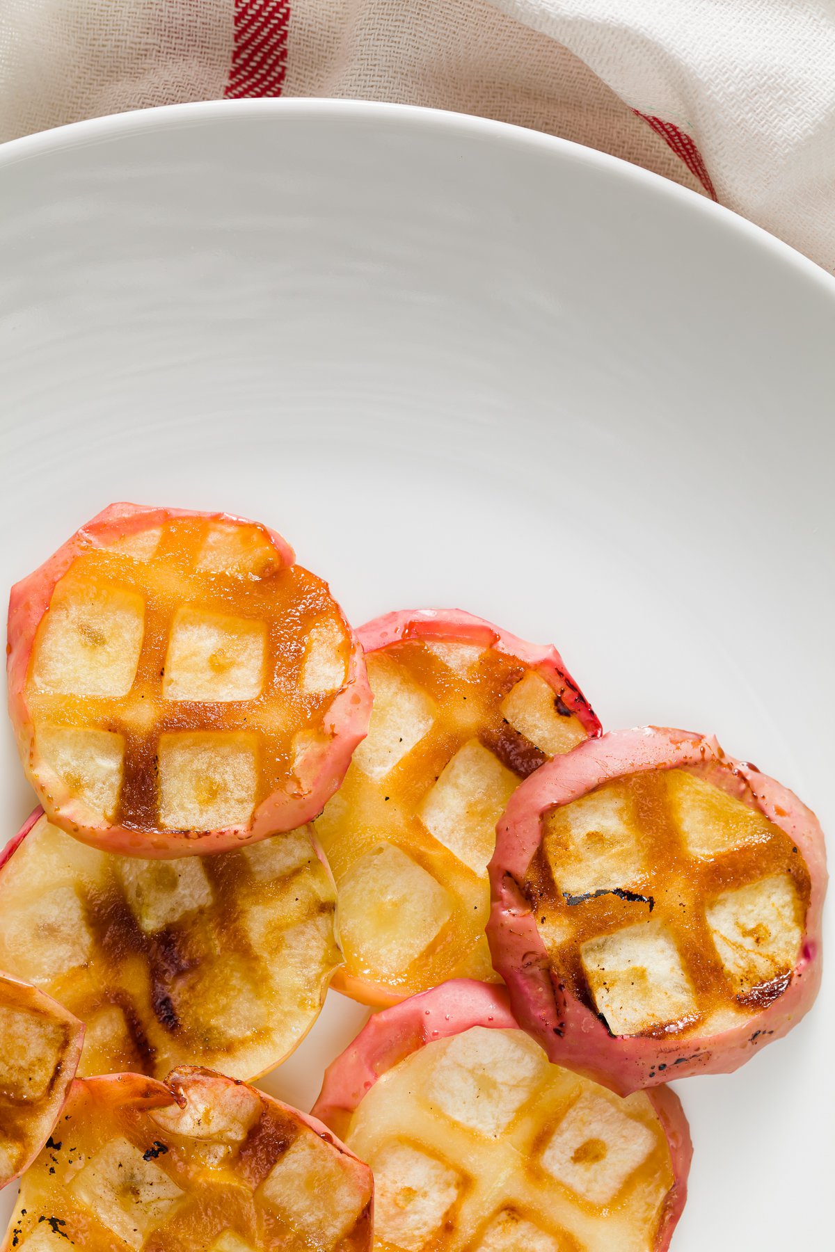 overhead view of a white plate with apple slices baked using a waffle iron