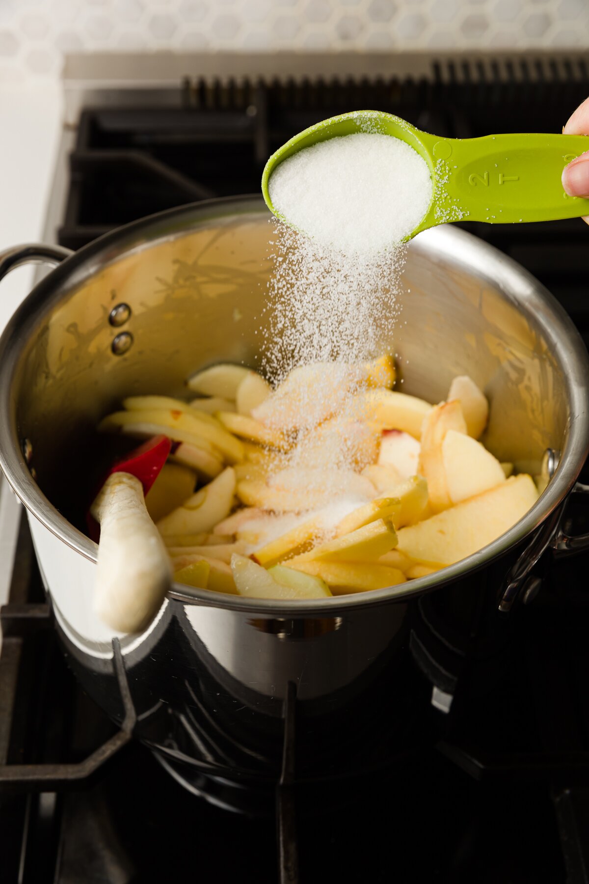 Add sugar to a pot of apples
