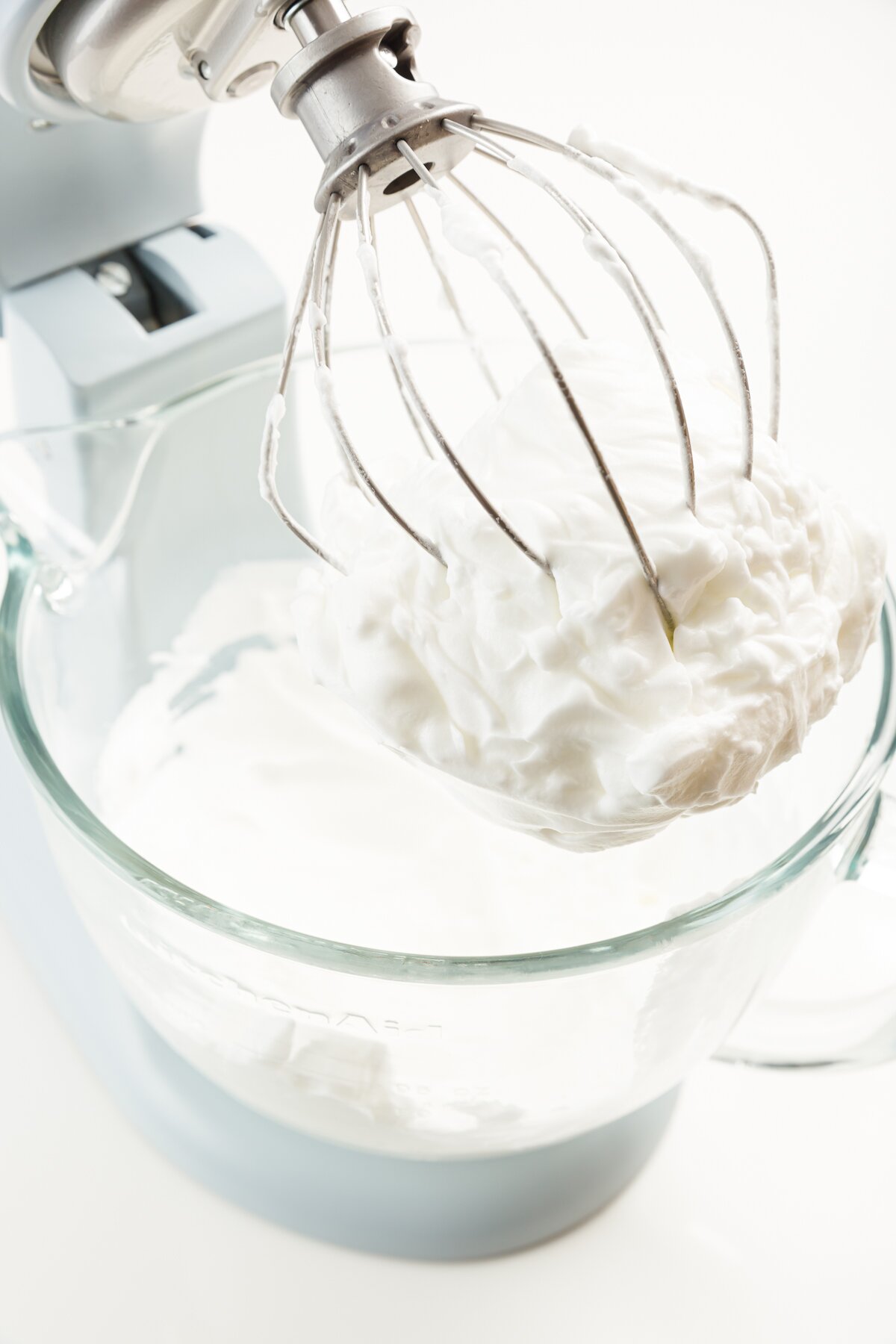 looking at a mixer bowl with egg whites whipped with cream of tartar to form stiff peaks