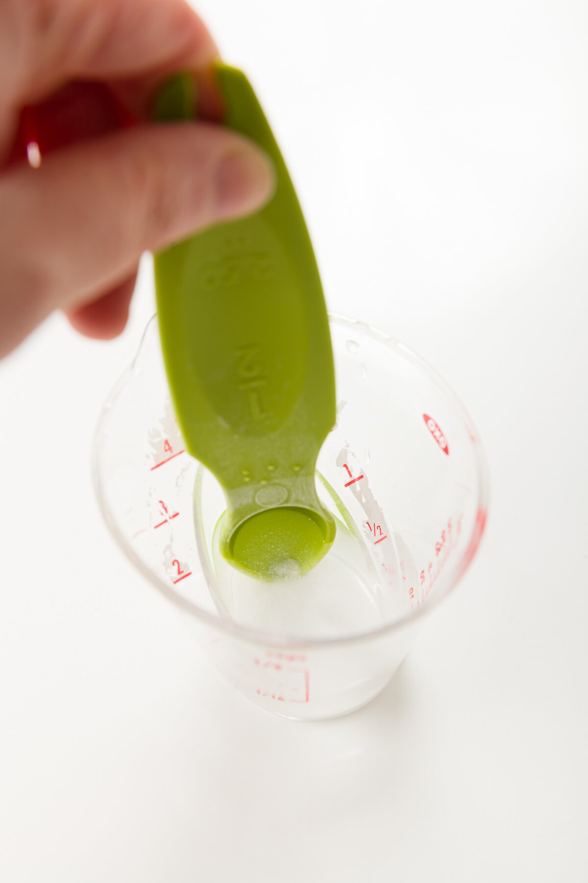 foto apretada de Stef mezclando bicarbonato de sodio en agua para formar una lechada