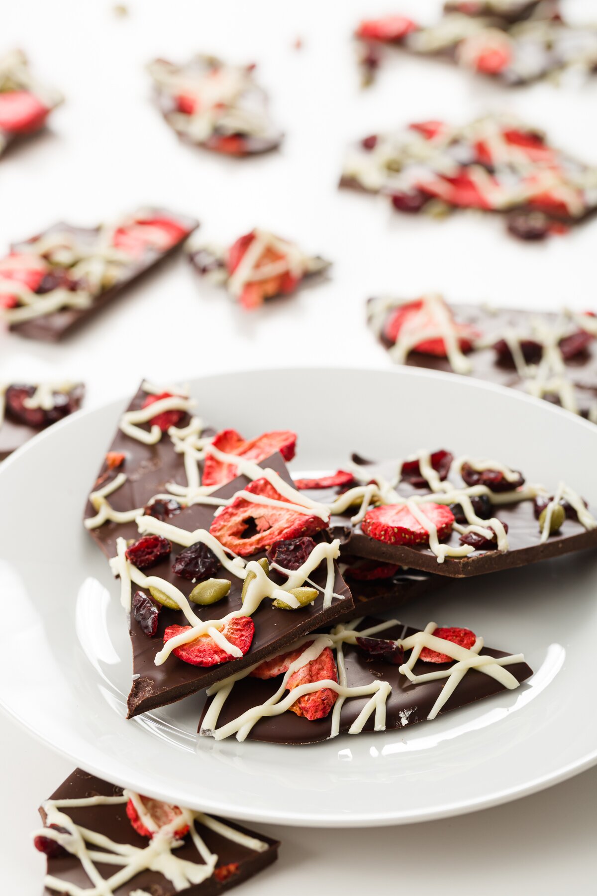 Plate of chocolate bark with extra pieces in the background