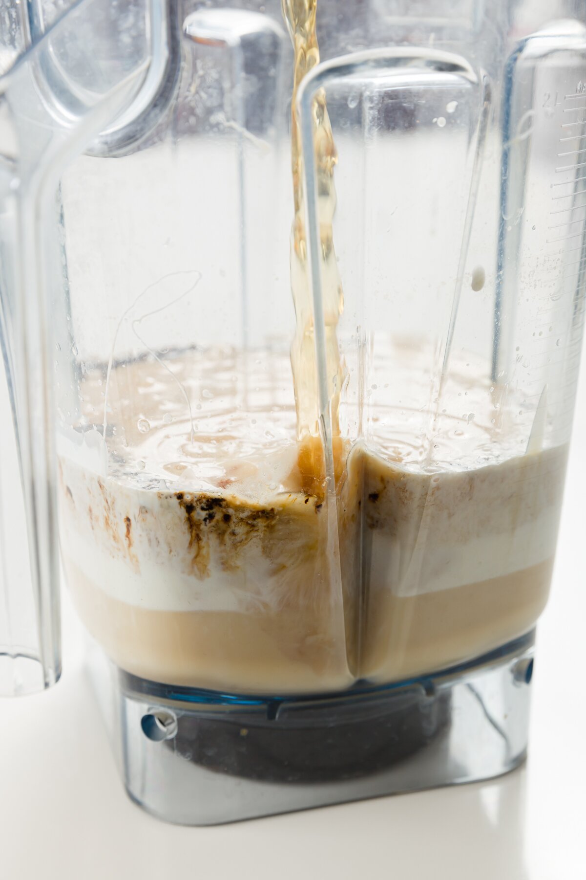 looking across a blender at whiskey being poured to combine with other Baileys ingredients