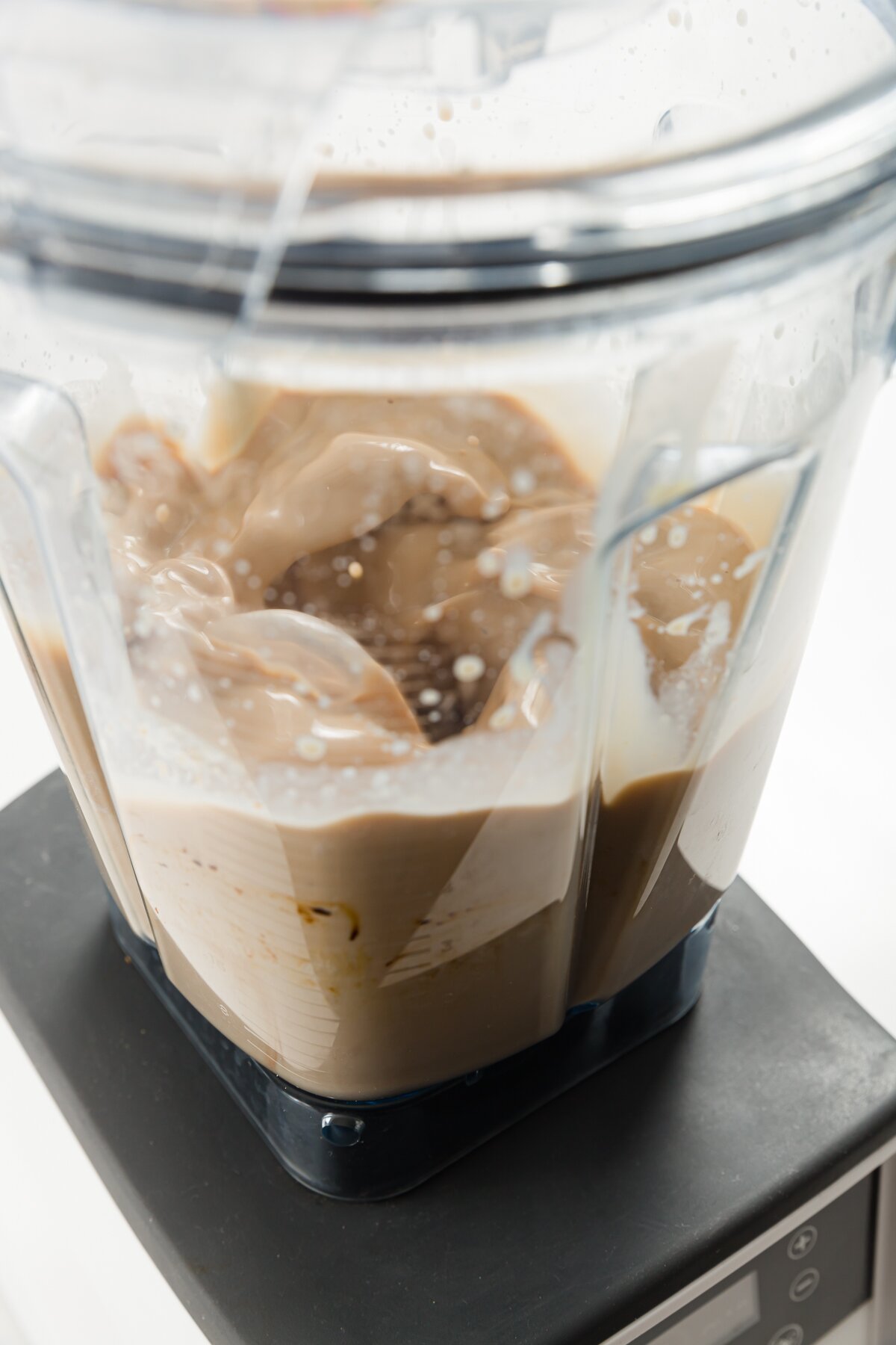 view of a blender mixing ingredients in homemade Baileys