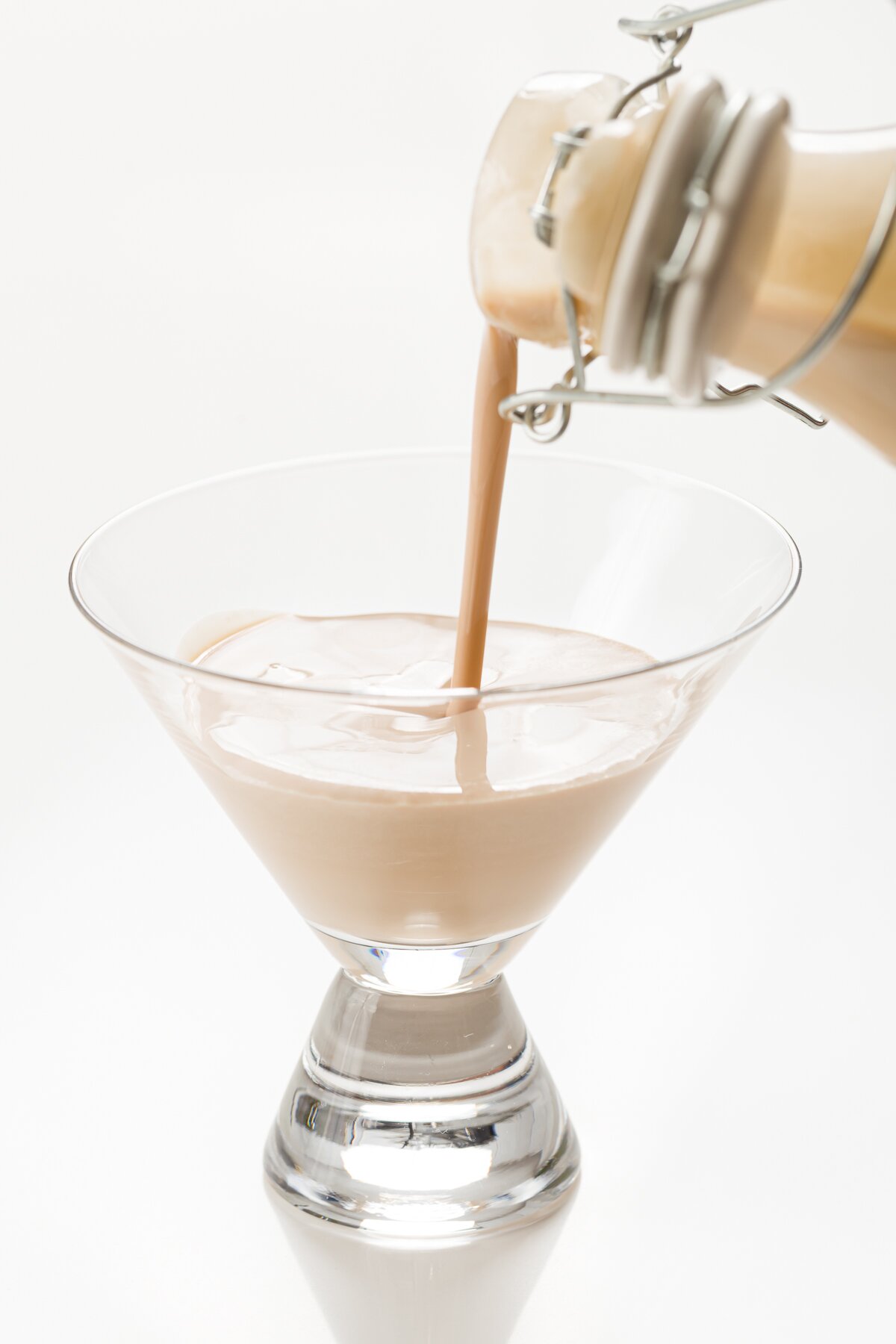 tight shot of homemade Baileys being poured into short martini glass