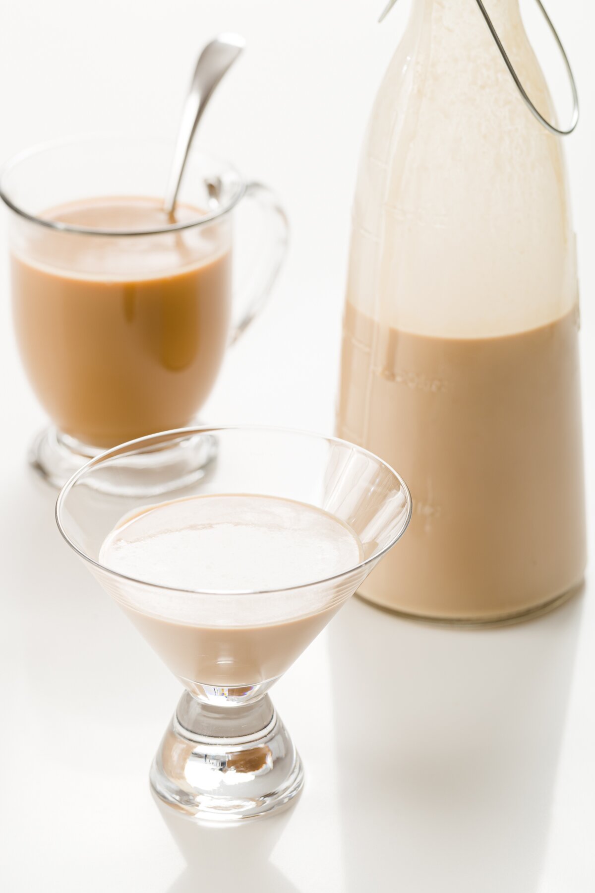 medium shot of a glass and bottle with homemade Baileys and a coffee mixed with homemade Baileys