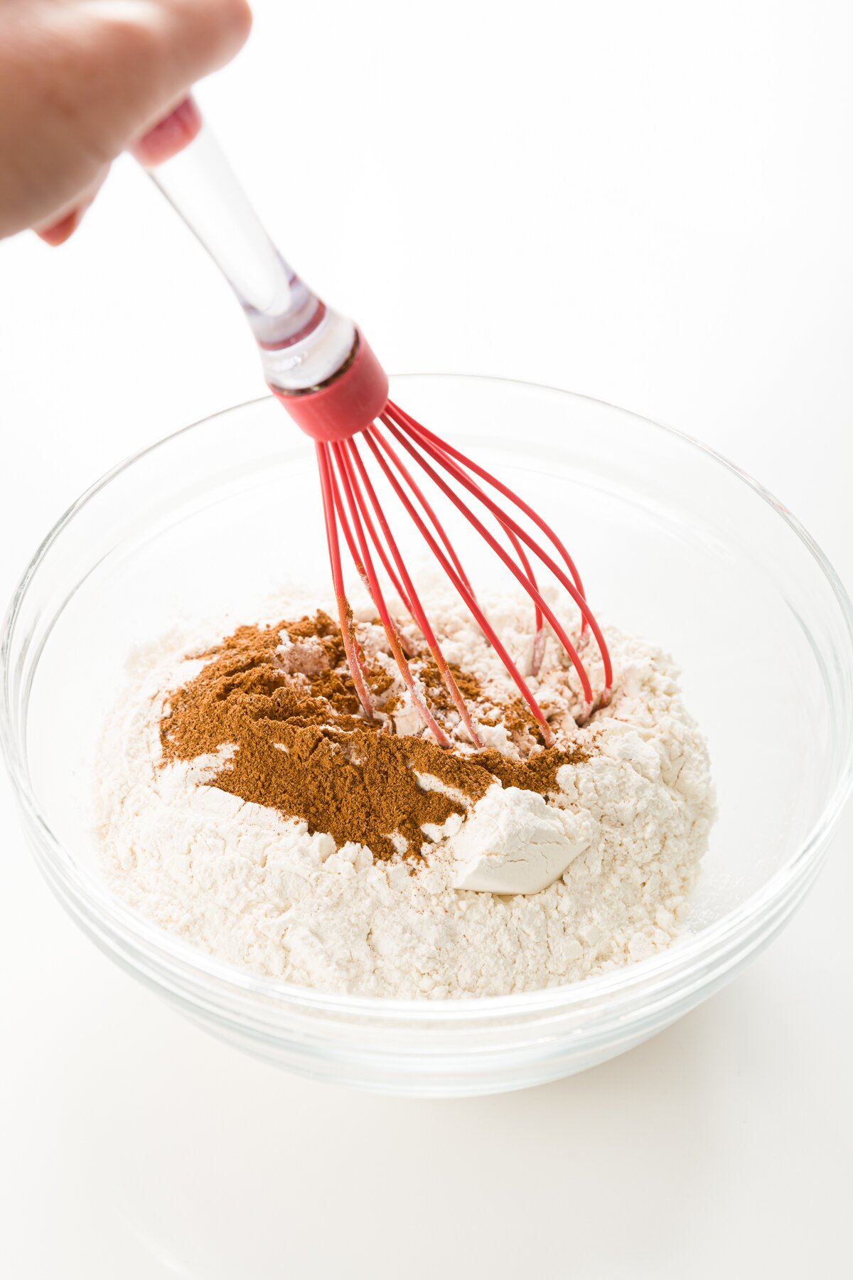 Stef's hand holding a whisk about to combine dry ingredients