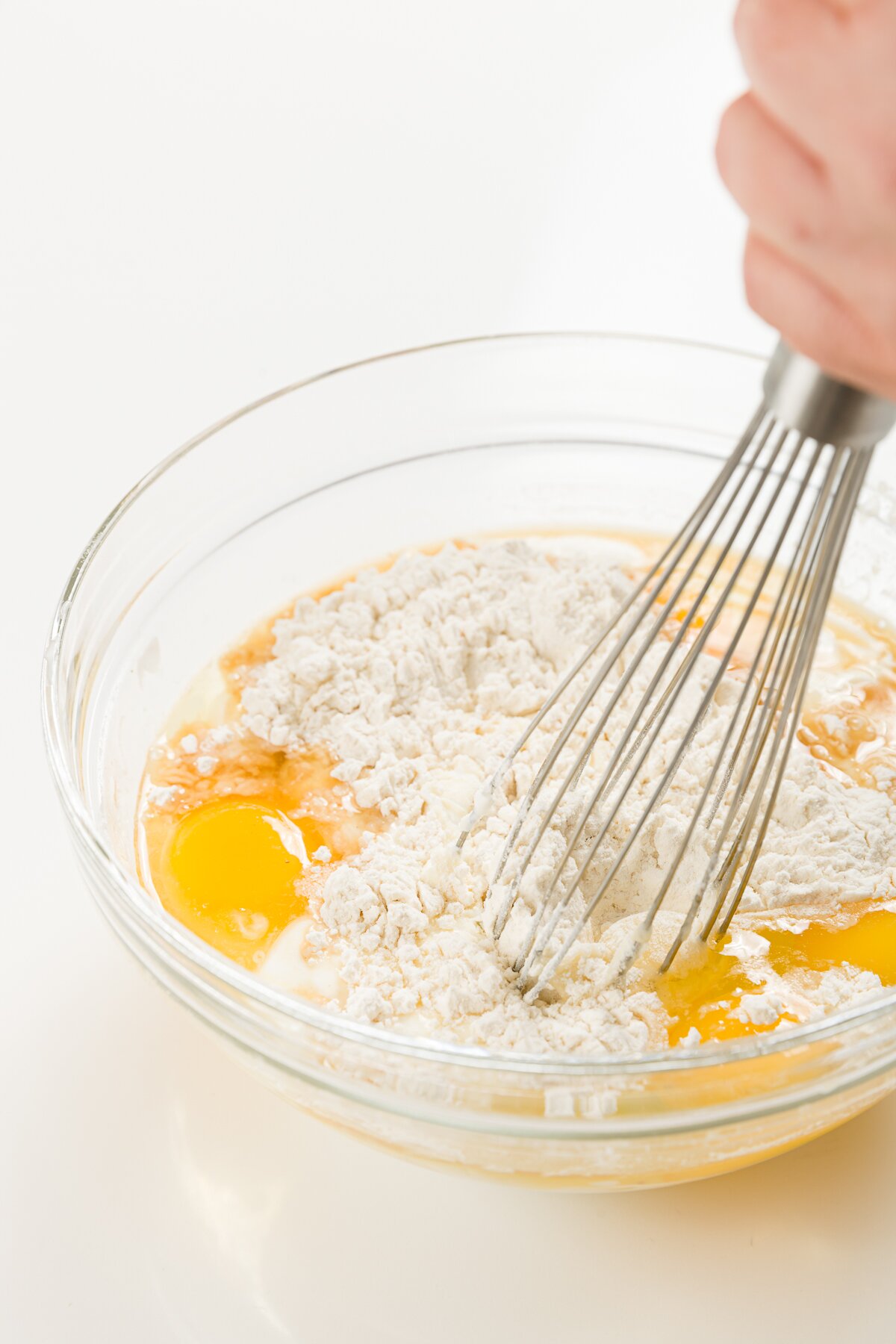 whisking eggs with other ingredients in a small glass bowl