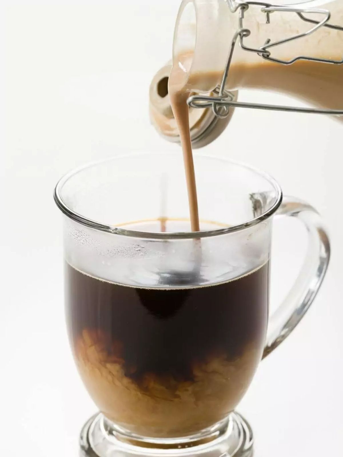 Homemade bailey's irish cream poured into a cup of coffee.