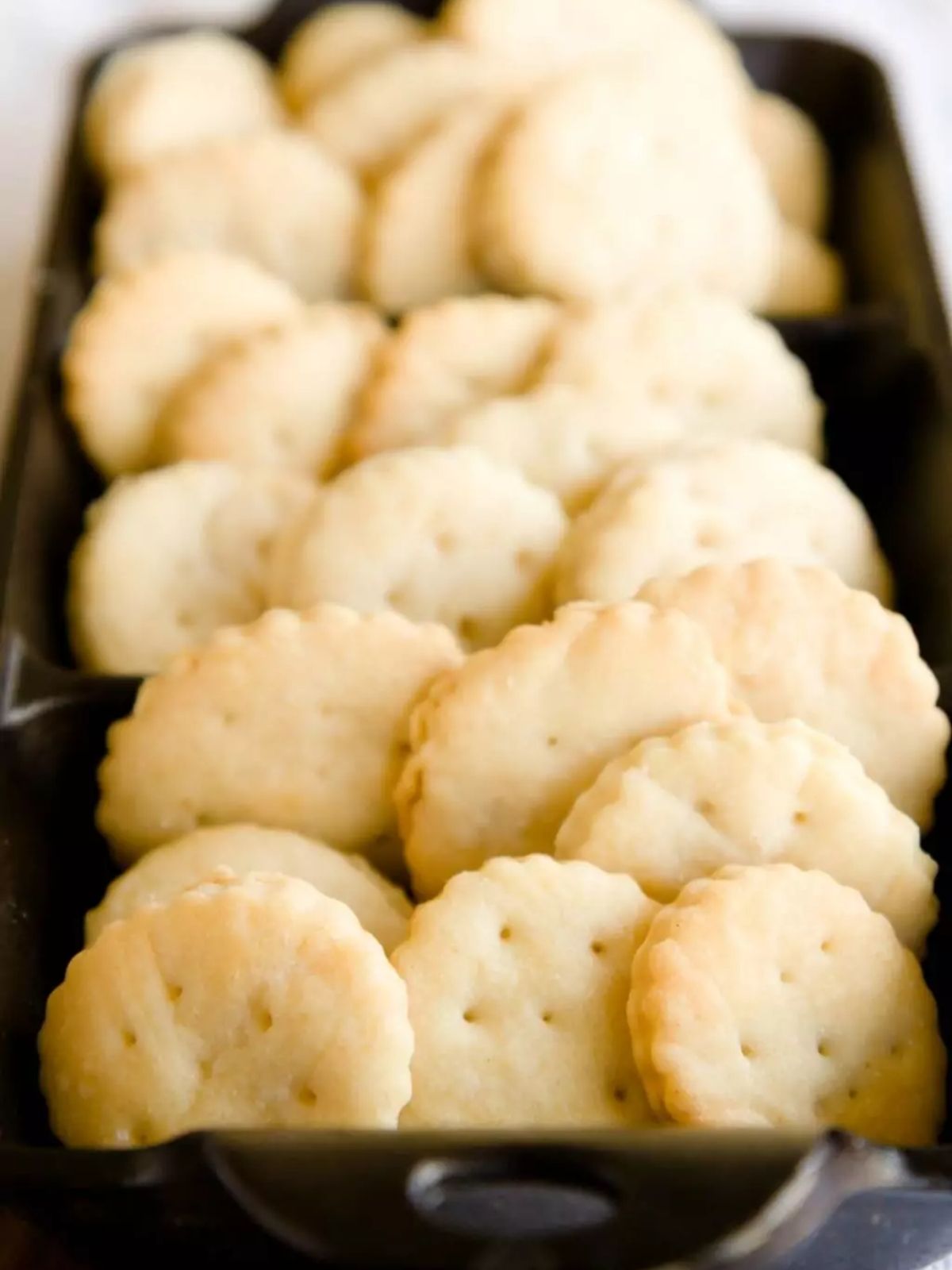 Ritz crackers in a dark pan.