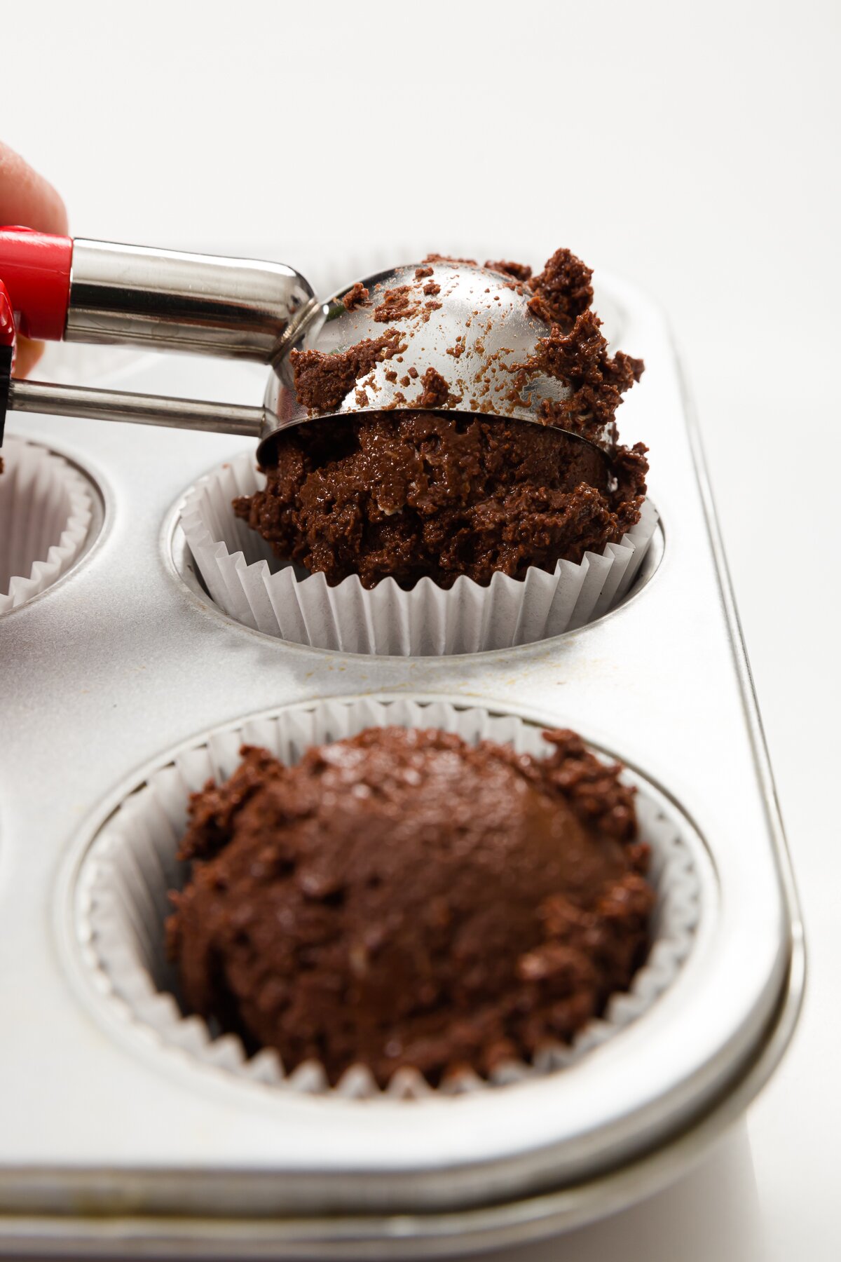 Filling cupcake liner with an ice cream scoop