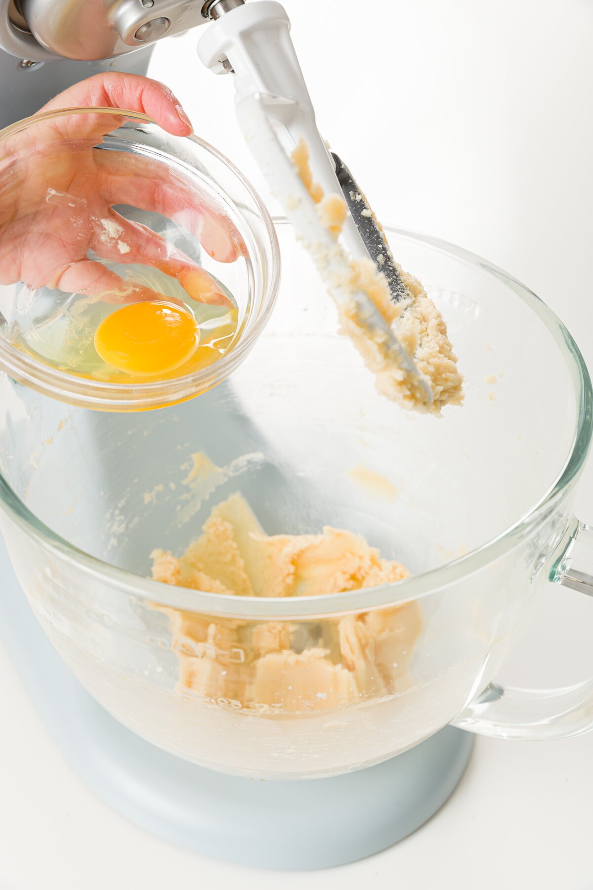 Adding egg to a bowl with a little batter