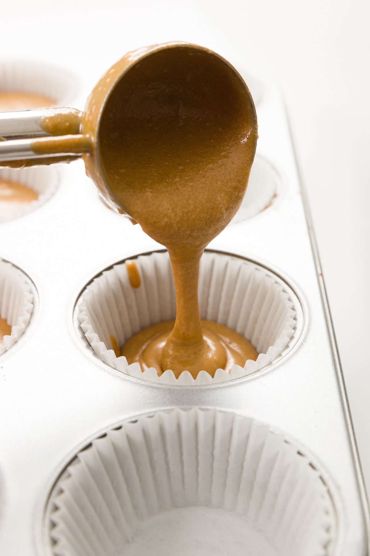 Filling cupcake liner with an ice cream scoop