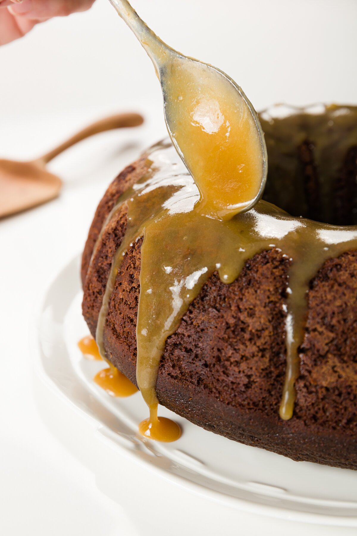 Pouring whiskey sauce over chocolate cake with a spoon