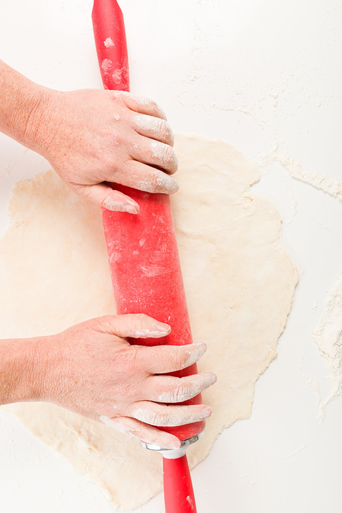Rolling dough with a red rolling pin