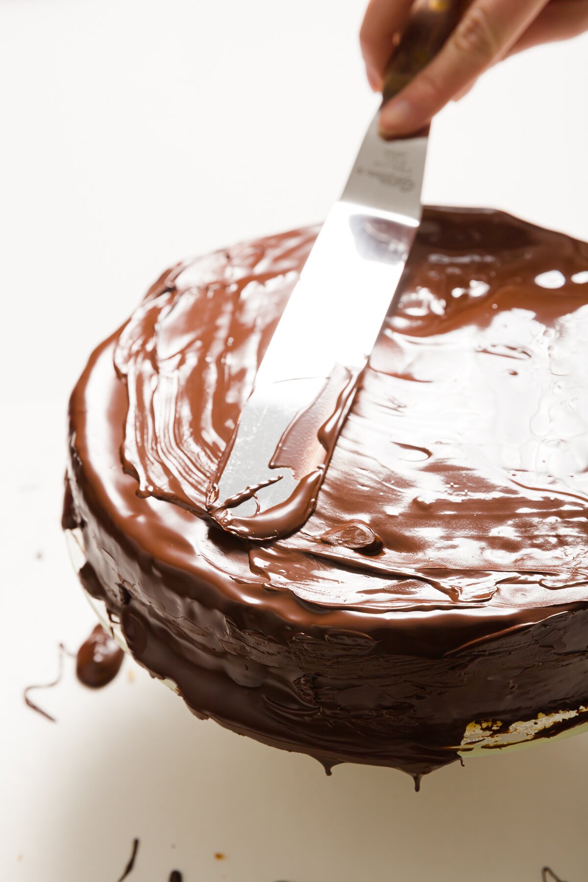 Smoothing out chocolate on top of a cake