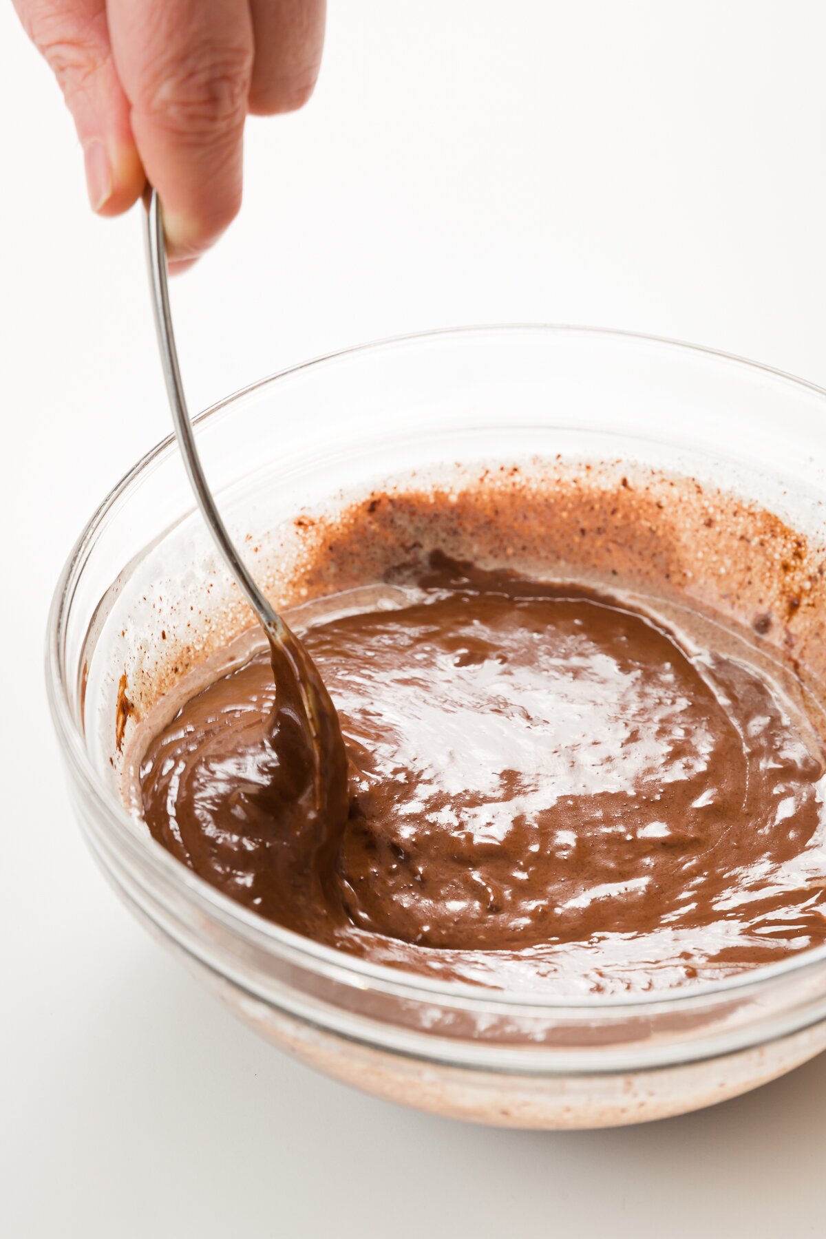 Stirring a bowl of chocolate mixed with cream