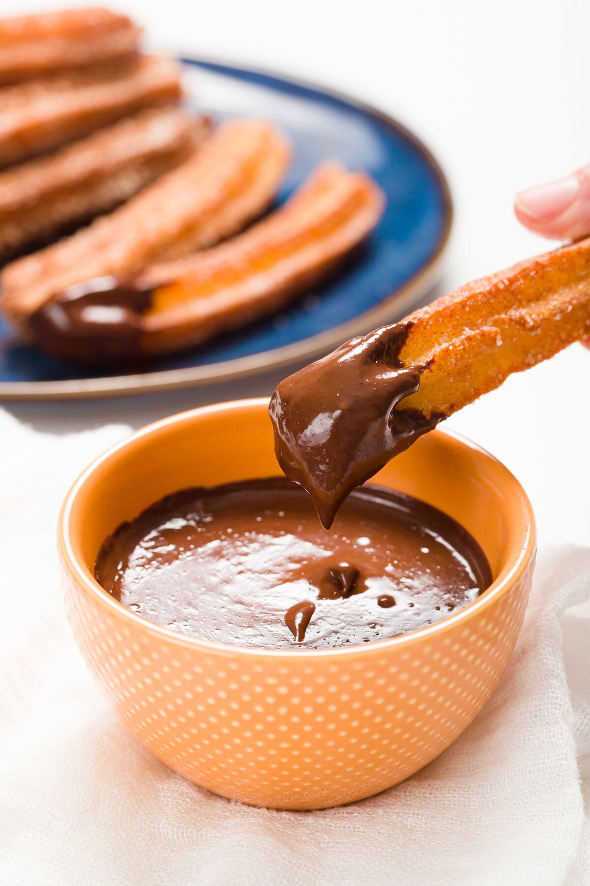 Dipping a churro into Mexican Chocolate Sauce