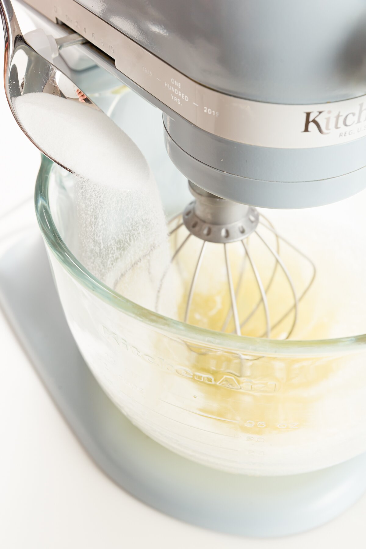 Adding sugar to whisked egg whites in a stand mixer