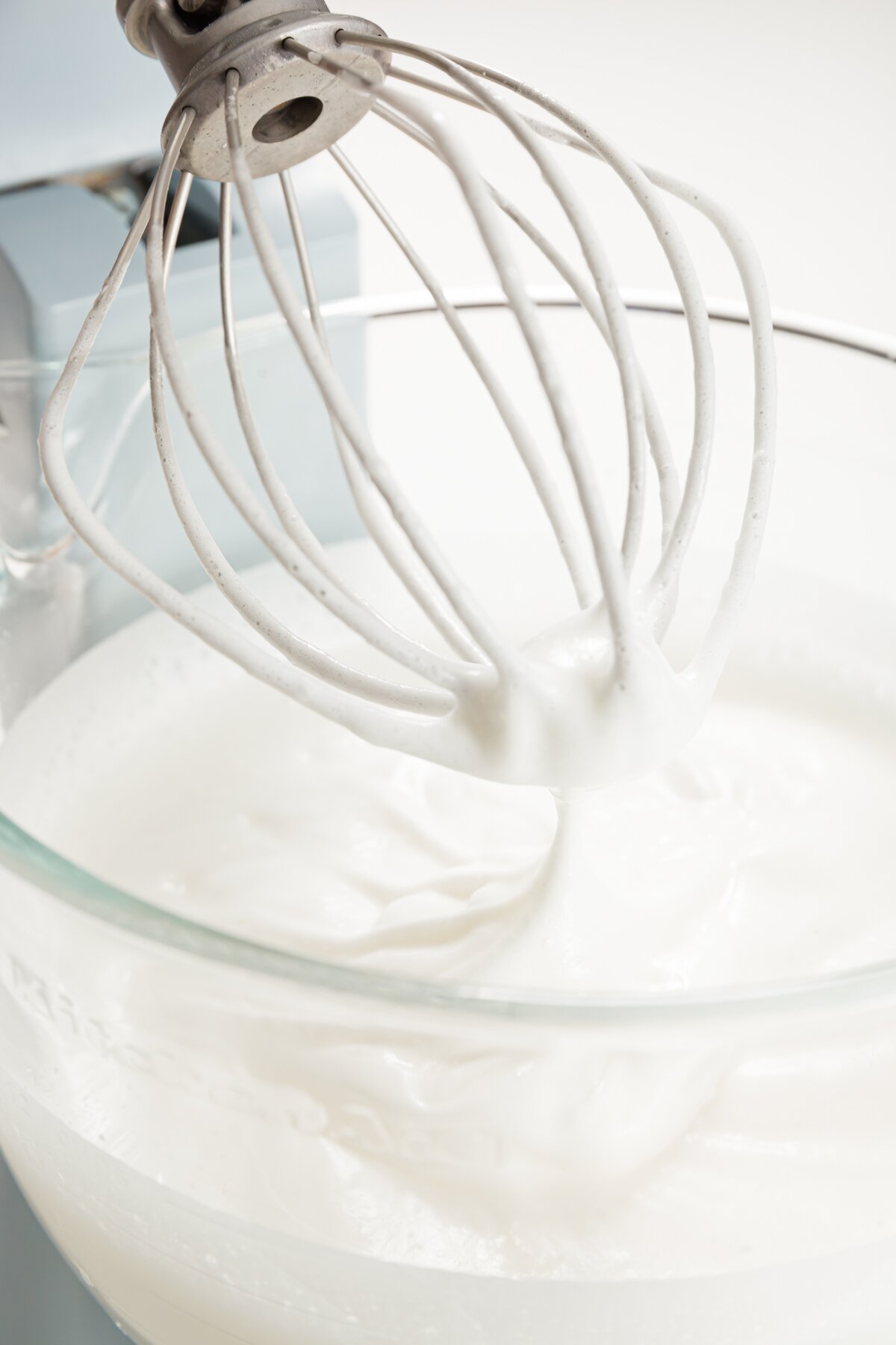 Egg white holding a peek when lifted from a whisk in a stand mixer