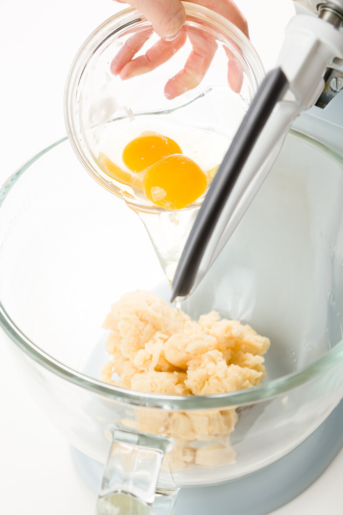 Adding eggs to glass stand mixer bowl