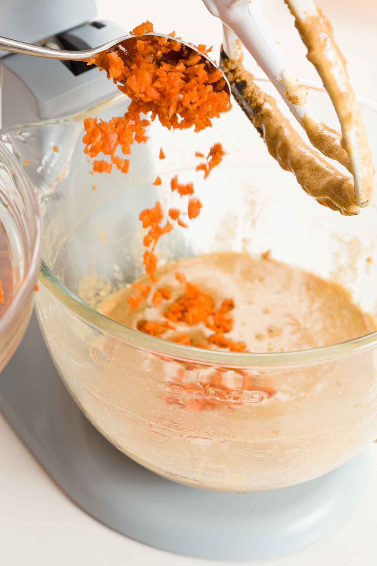 Carrot pouring into bowl of a stand mixer