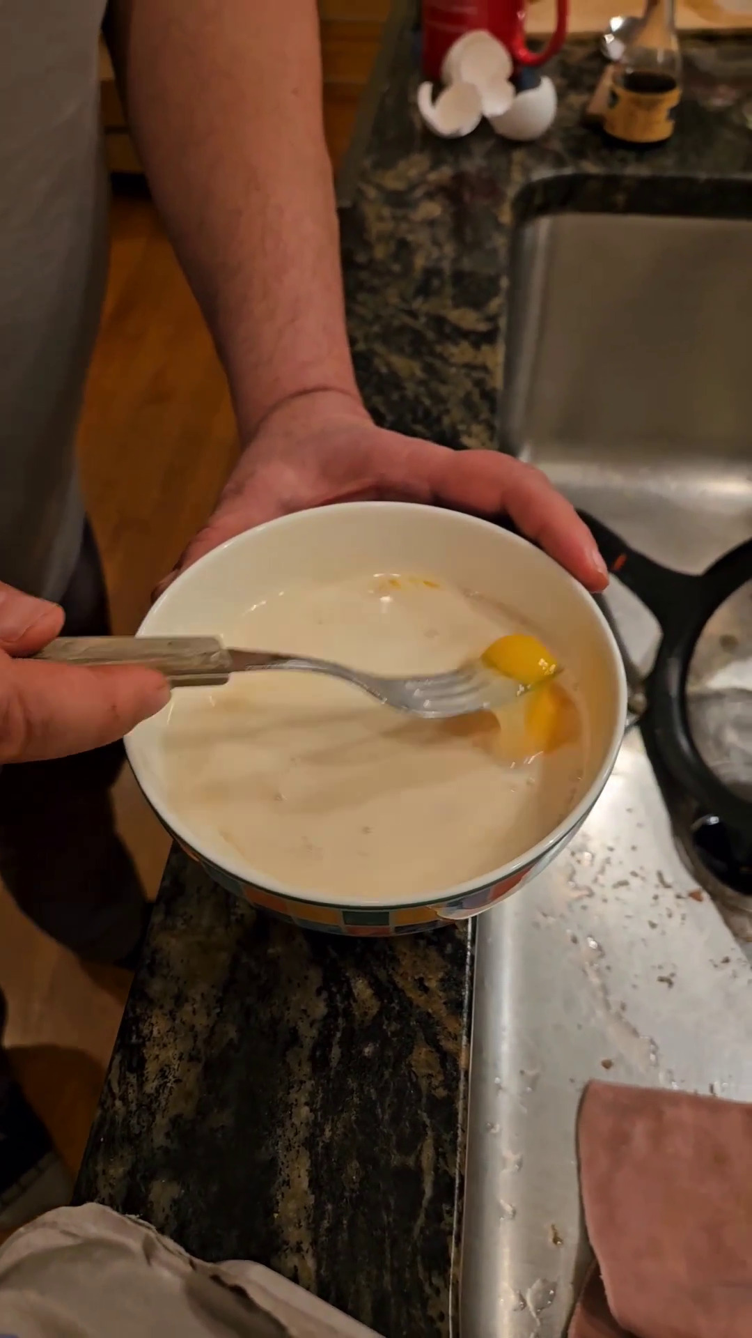 Using a fork to beat together eggs, milk, sugar, and vanilla.